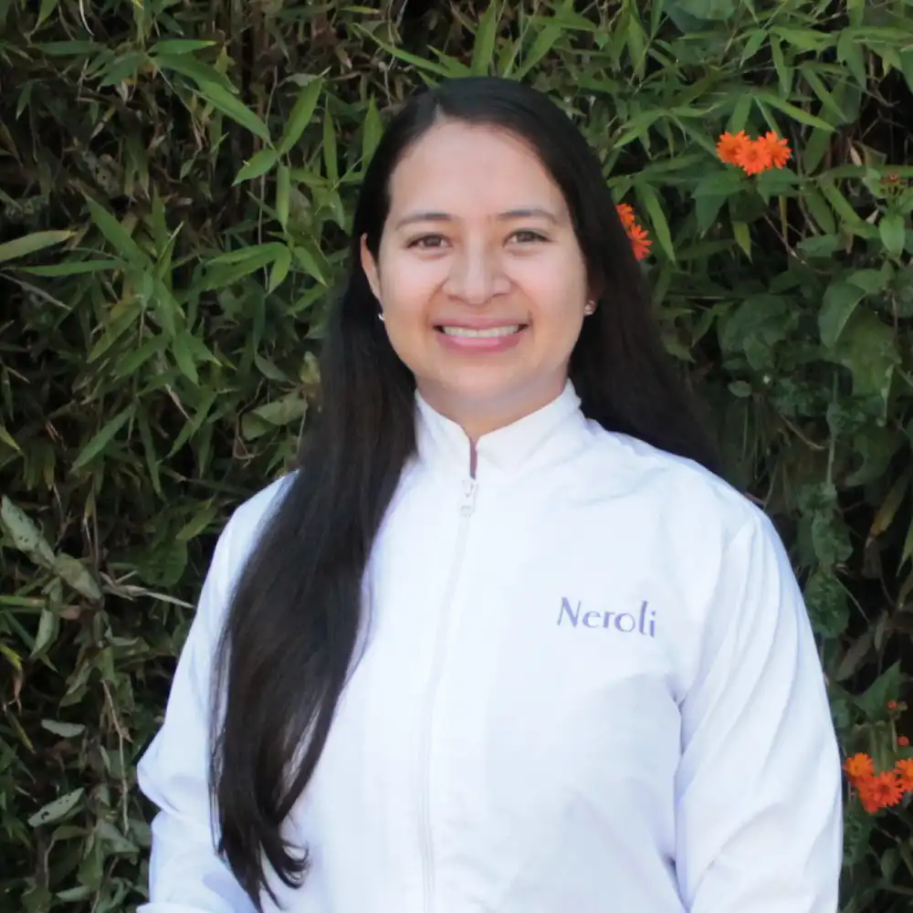 Mujer con bata de laboratorio sonriendo (foto analista idi Neroli)